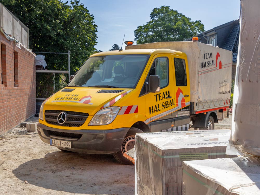 Einsatzfahrzeug von Team Hausbau auf einer Baustelle