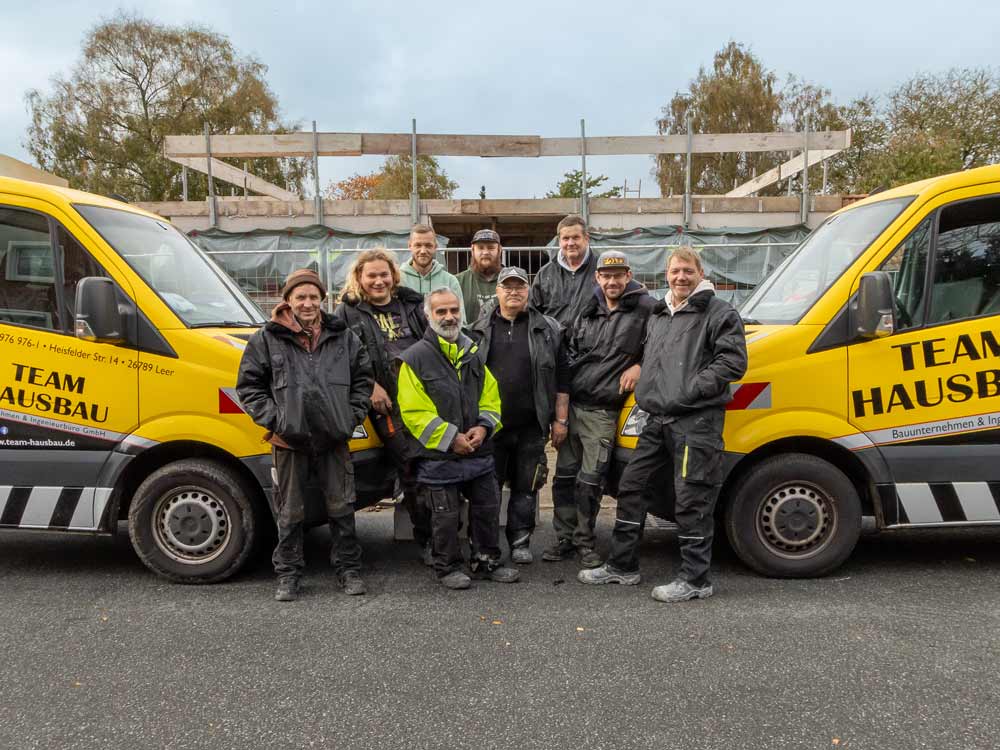 Das Team von Team Hausbau vor einer Baustelle
